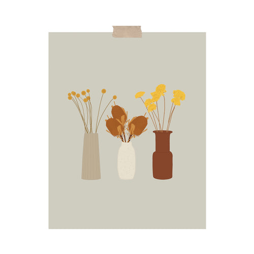 An art print featuring three vases with different warm-toned dried flowers in them hung with a piece of kraft tape on the top.