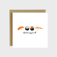 Load image into Gallery viewer, A funny greeting card featuring a piece of salmon nigiri, shrimp nigiri, California roll, and tuna roll with text that reads, I like the way you roll.
