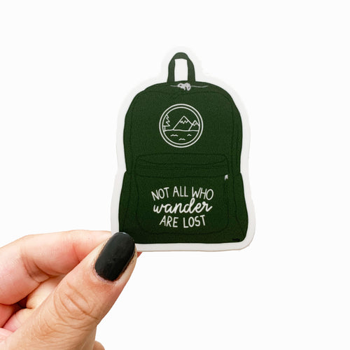 A sticker featuring a green backpack with an outdoor scenery logo and text that reads, Not all who wander are lost.