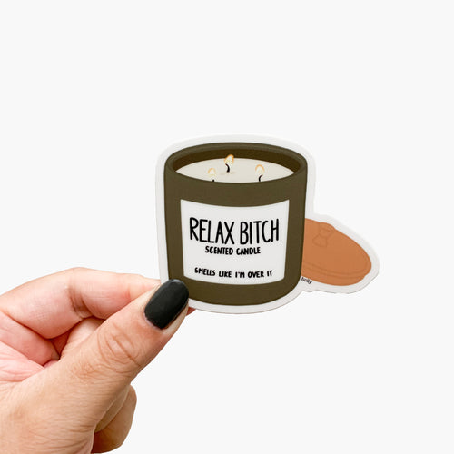 A funny sticker featuring a muted green lit candle with a brass top and text that reads, Relax bitch scented candle, smells like I’m over it.