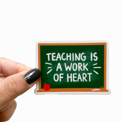 A sticker featuring a green chalkboard and text that reads, Teaching is a work of heart.