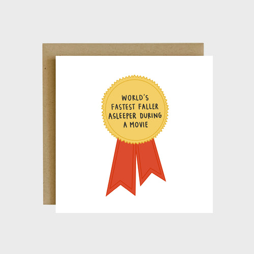 A funny greeting card featuring a ribbon award and text that reads, World’s fastest faller asleeper during a movie.